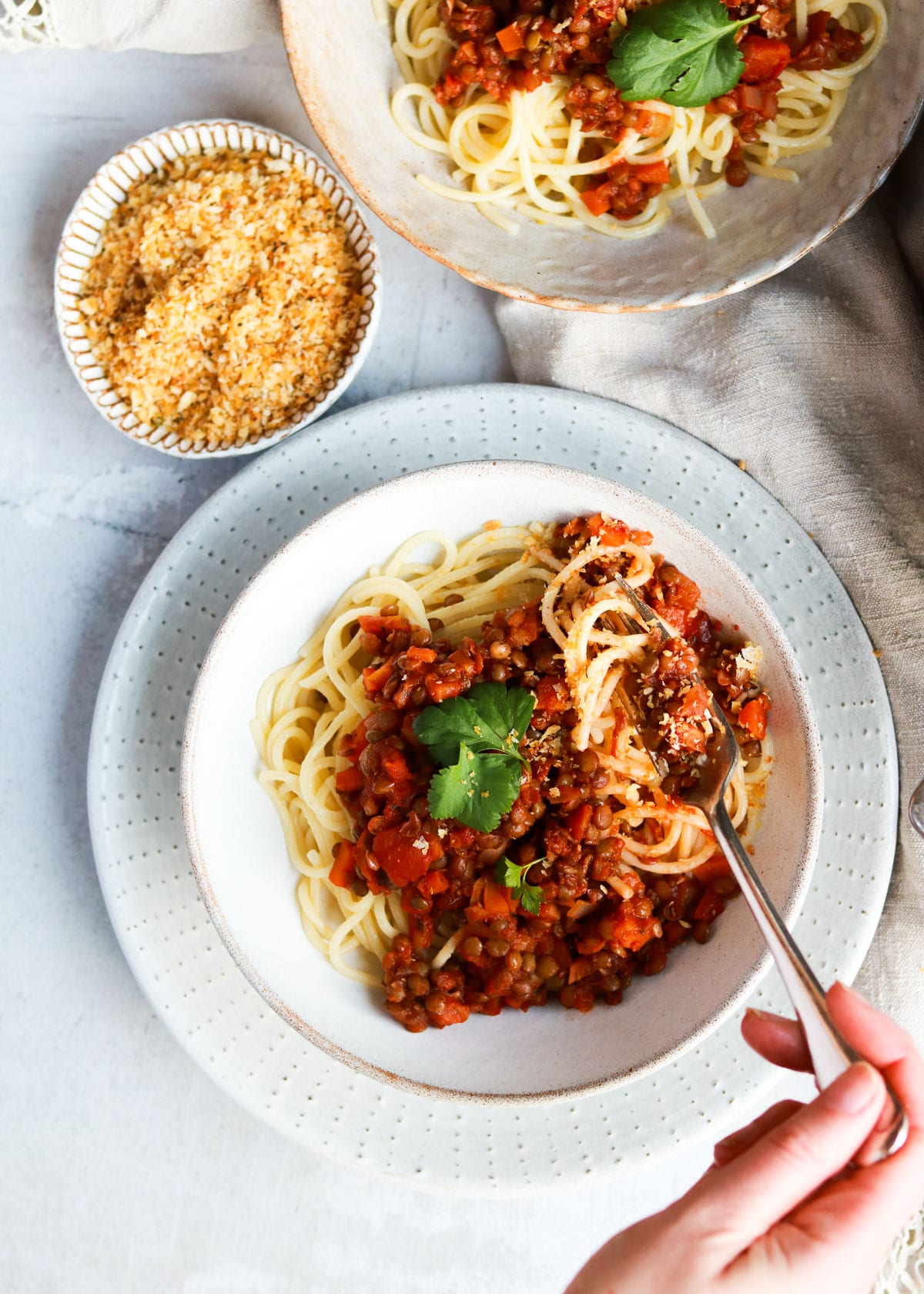 Lentil Bolognese being scooped up with a fork.