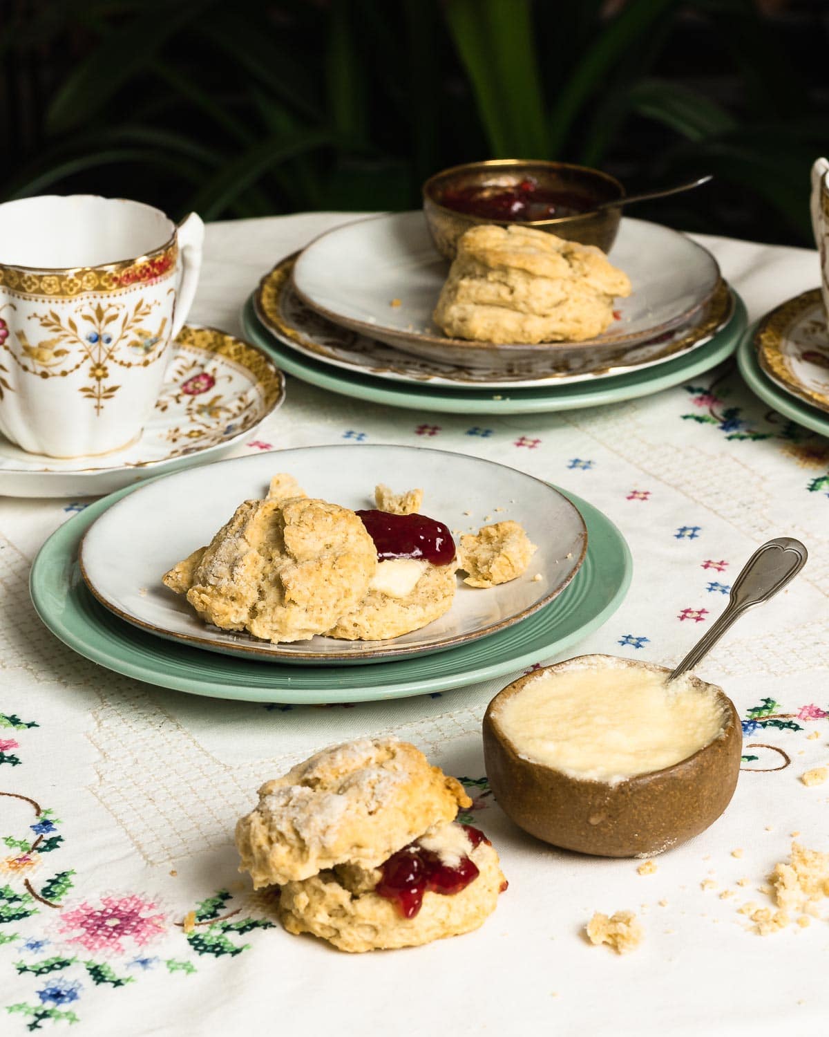 vegan clotted cream in a pot next to a plate with a scone and jam.
