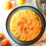 Citrus Cake on a plate, decorated with slices of orange and lemon ready to cut.