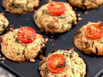 Vegan Spinach Muffin in a tin topped with cherry tomatoes