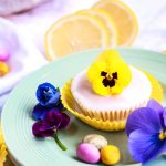 Vegan Lemon Cupcakes with a flower on top on a plate.