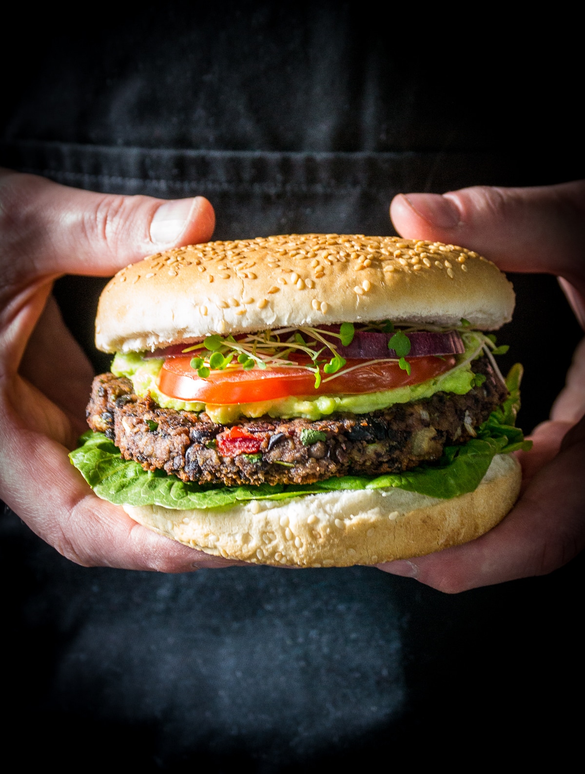 vegan burger in a bun held by hands