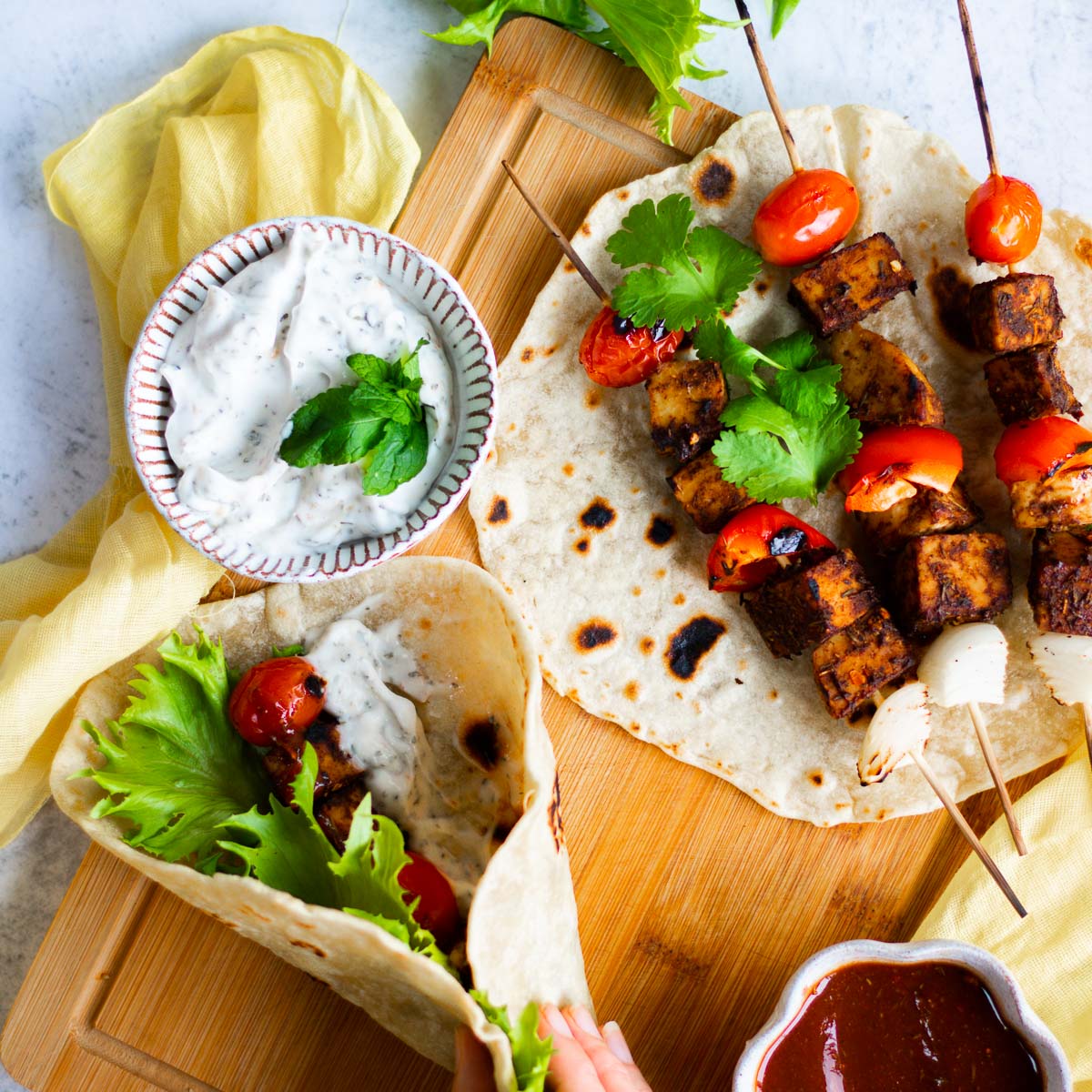 a vegan wrap made with roti, filled with jerk tempeh