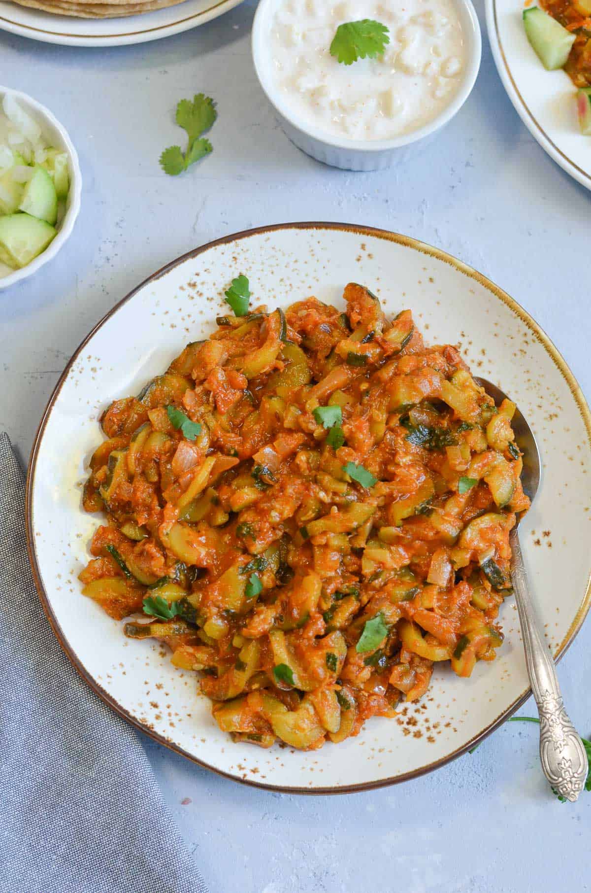 Indian Zucchini curry on a plate with a spoon