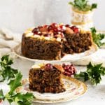 vegan christmas cake on a plate with a slice out of it