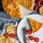 Pasta frittata on a plate with extra frittata next to it.