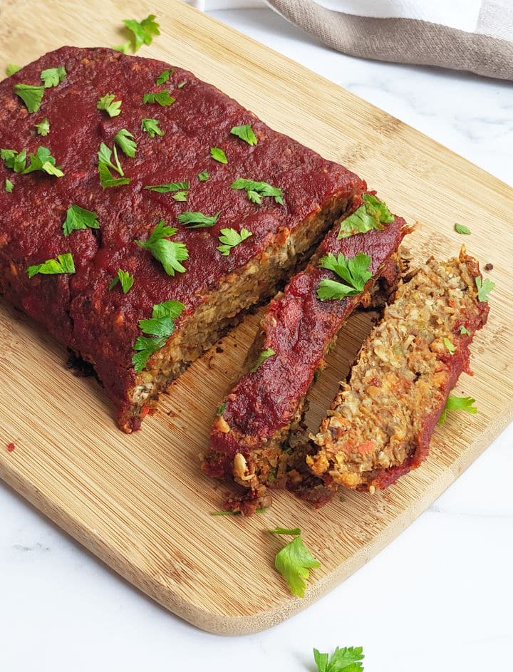 Vegan Lentil Loaf cut up on a wooden board.