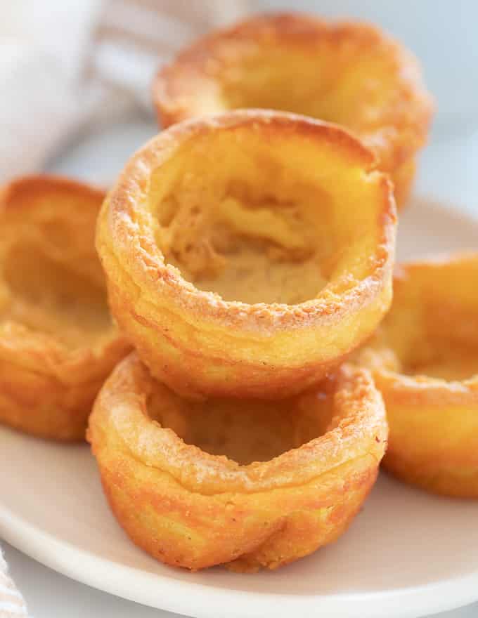 vegan yorkshire puddings stacked up on a plate.