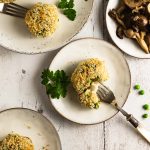 A vegan mushroom arancini on a plate with a fork.