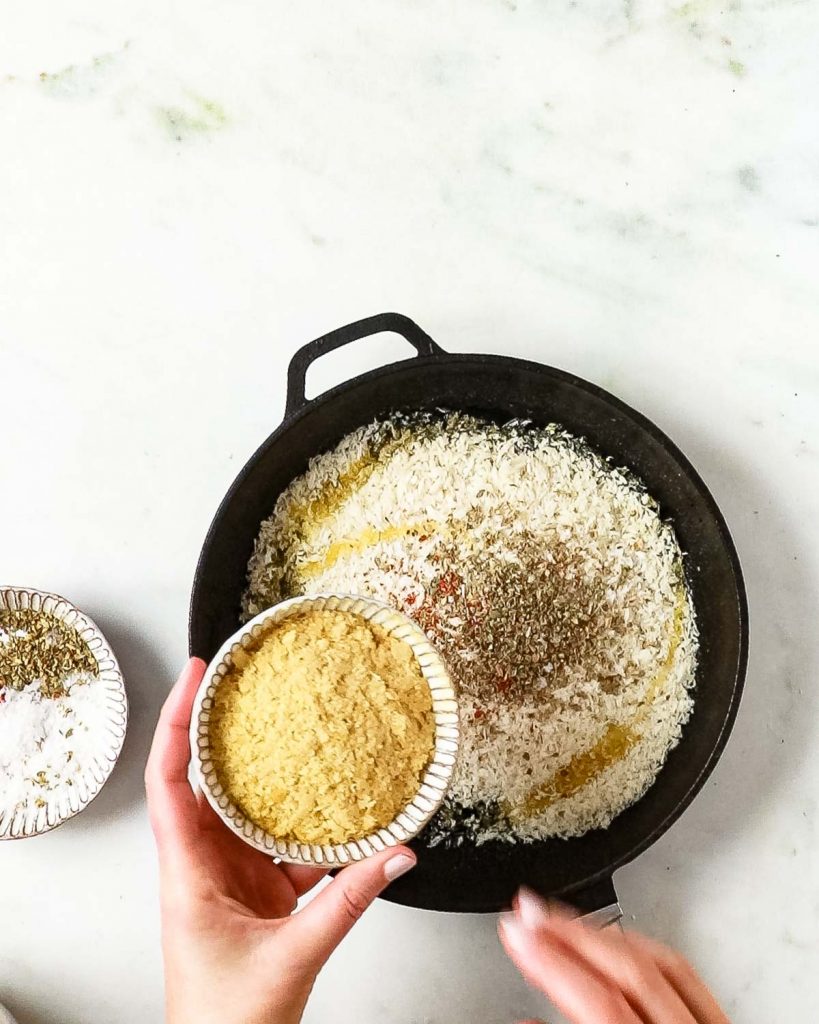 Adding the nutritional yeast to the pangritata.