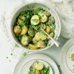 Potato salad with dill and peas in a bowl ready to serve.