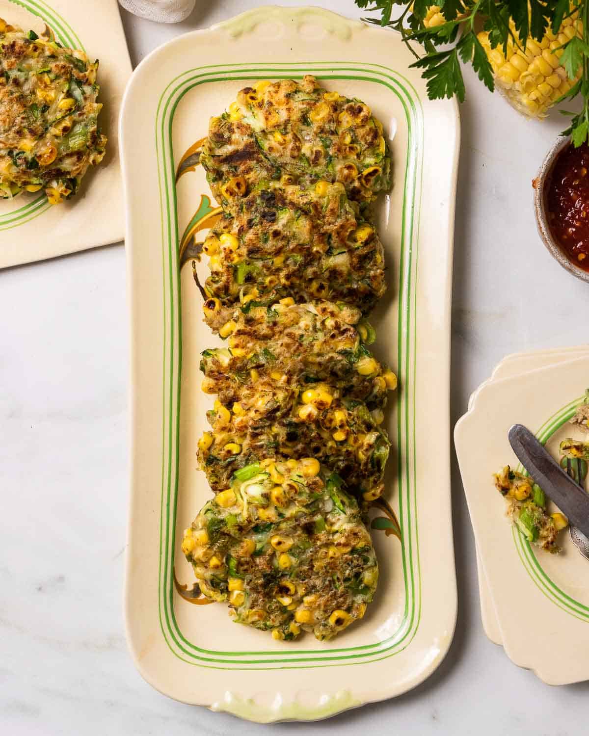A plate of vegan courgette and sweetcorn fritters.