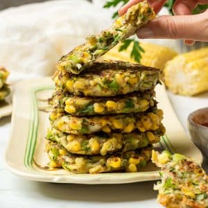 A stack of vegan corn and courgette fritters.