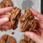 Peanut Butter chocolate chip cookie being broken to show the melted chocolate chips.