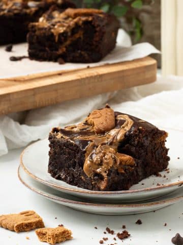 A vegan biscoff brownie on a plate, really needs to be eaten asap!