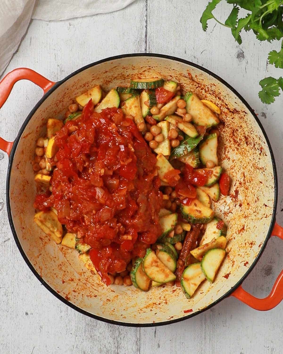 Add the tomato masala base back to the courgettes and chickpeas.