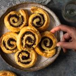 Puff pastry pinwheels with tapenade inside them on a plate, ready to serve.