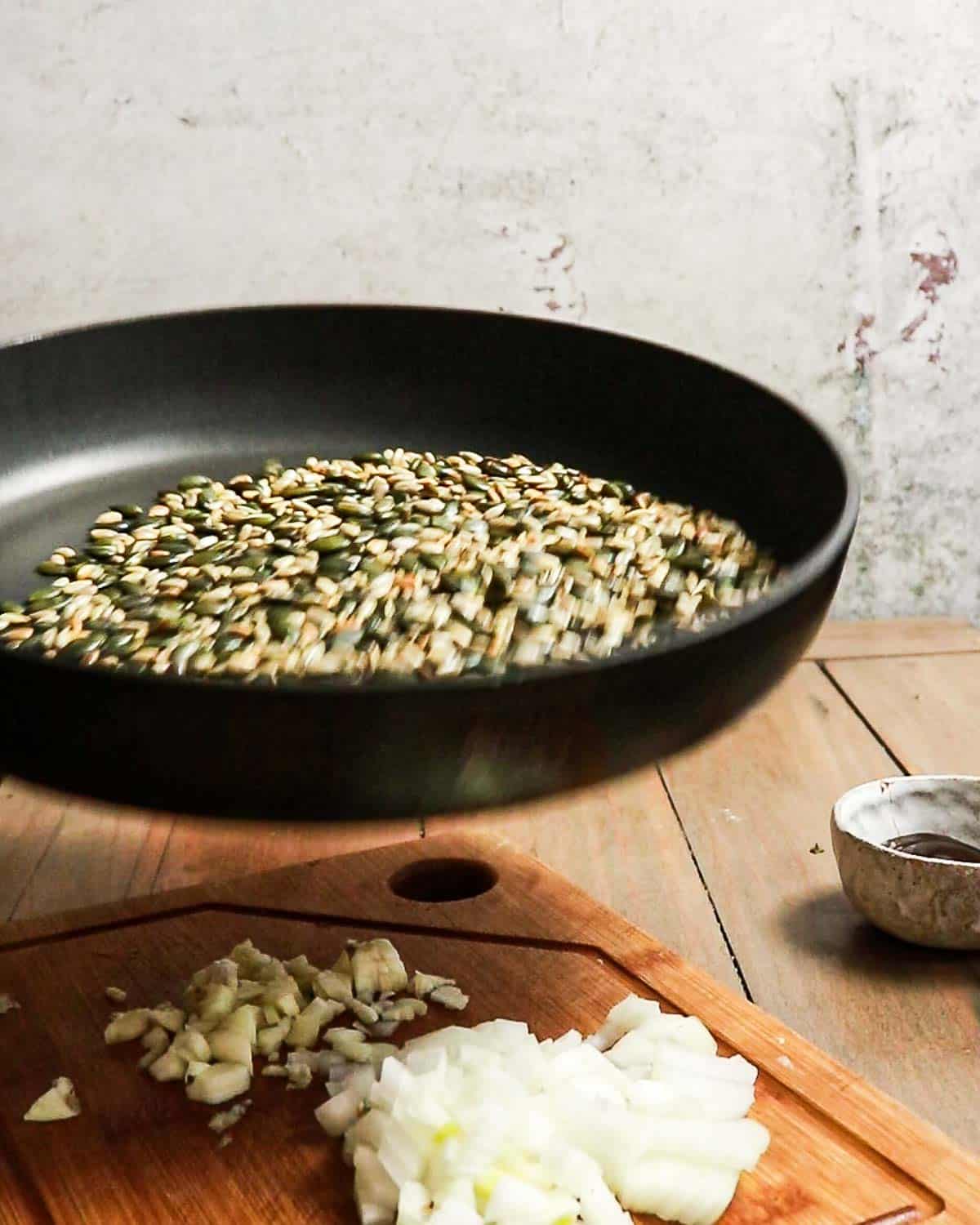 Seeds being toasted in a pan.