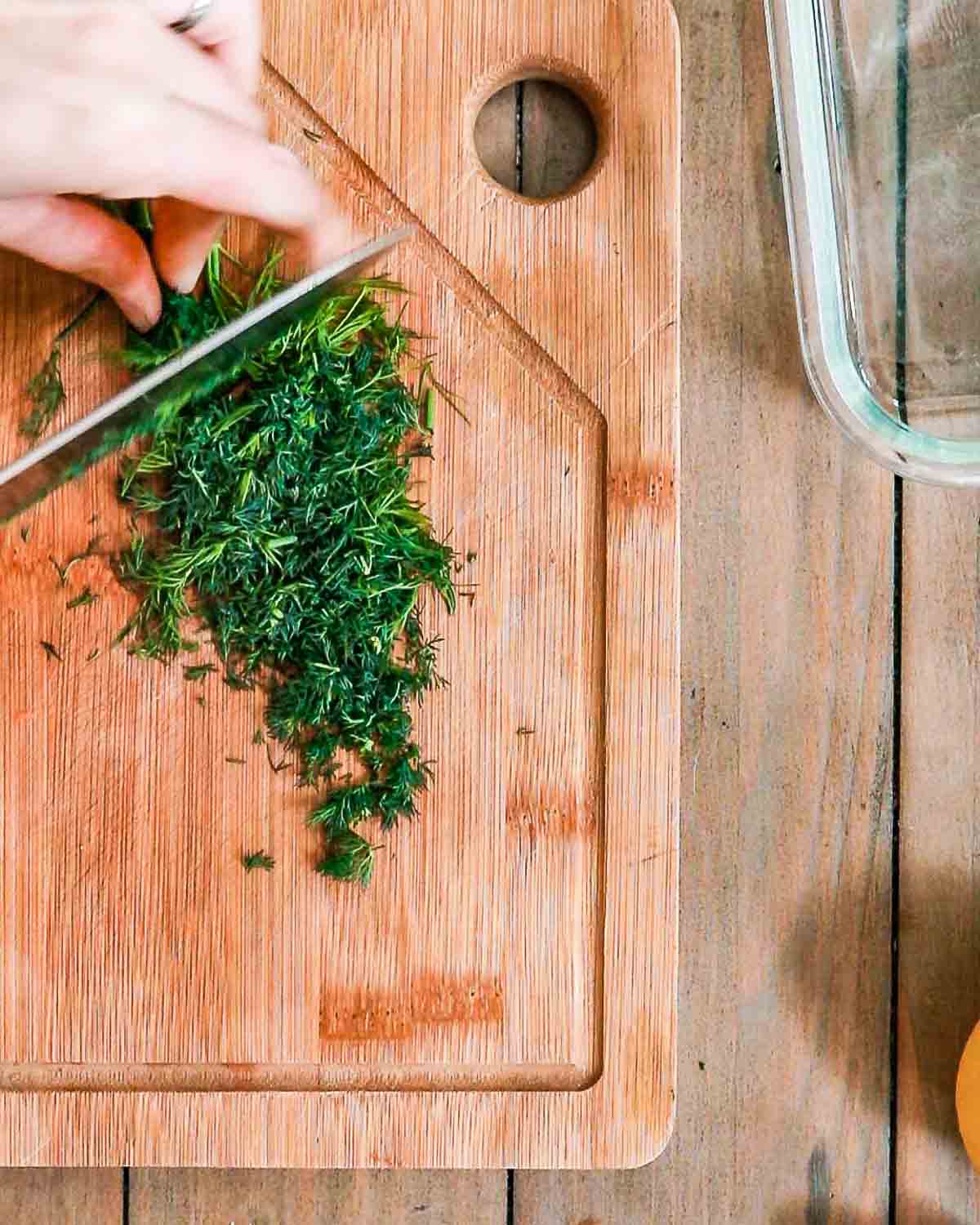 Finely chopping dill to make the marinade. 