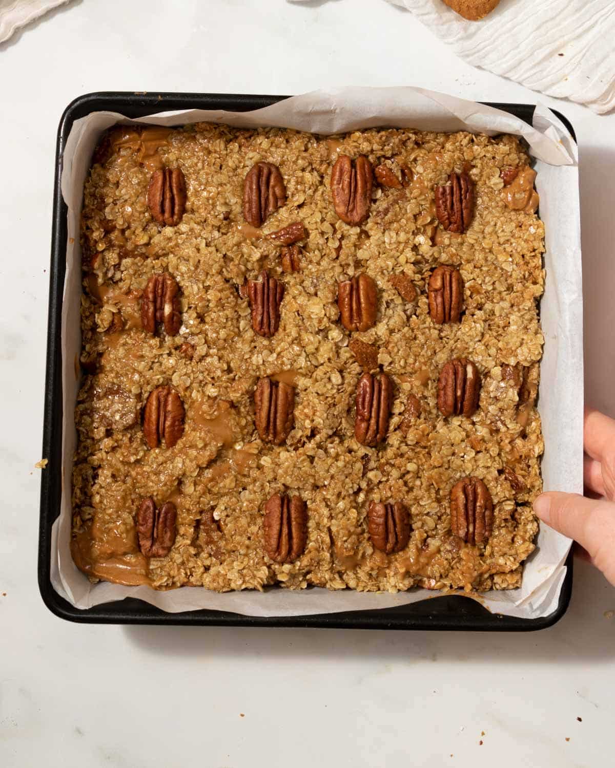 Make sure oat mixture is fully patted down. Add nuts on top if desired. Bake.