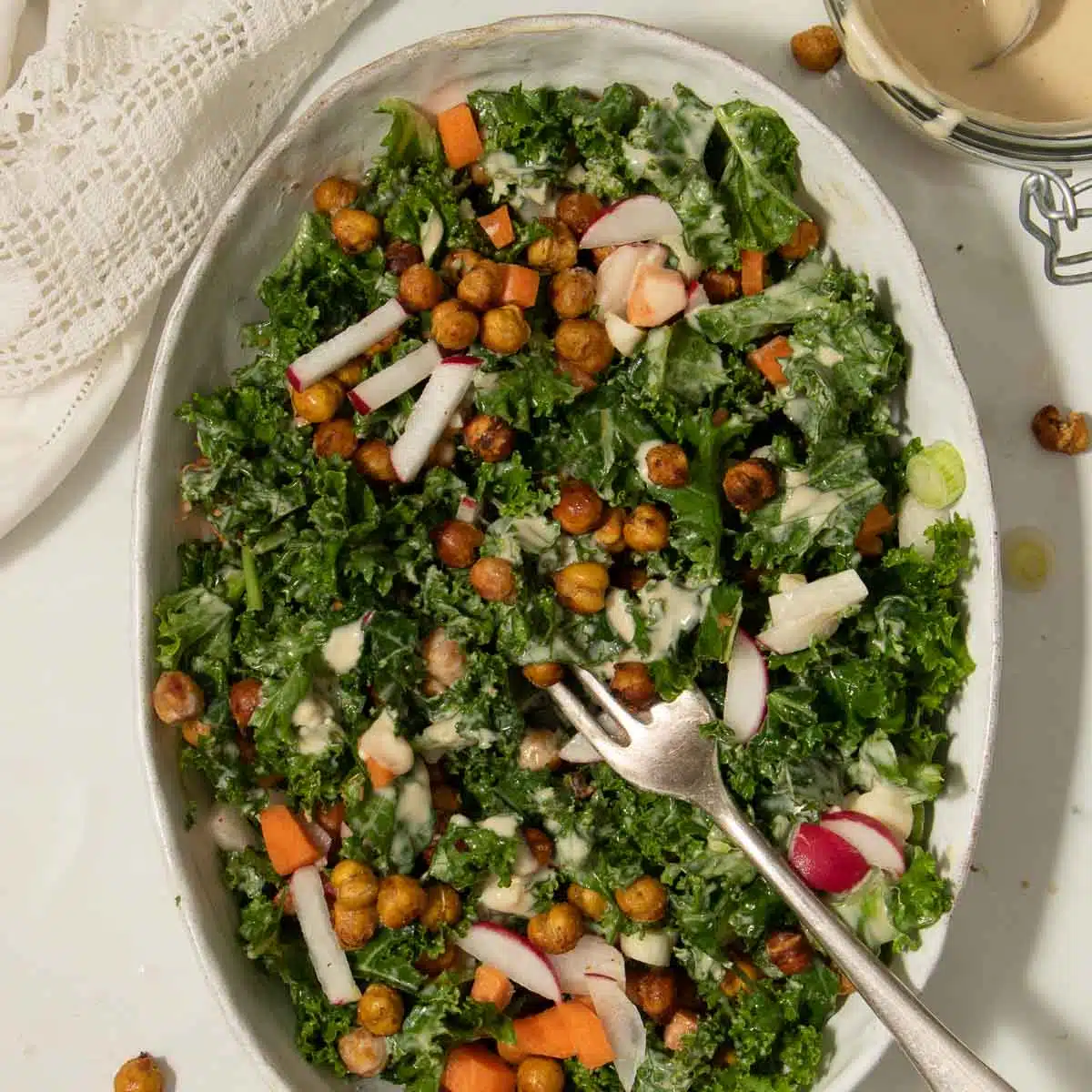 Kale and Tahini Salad in a bowl with extra chickpeas sprinkled on top. Ready to eat.