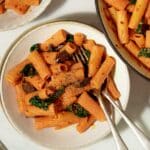 A bowl of cream harissa pasta with a fork in it, ready to eat.