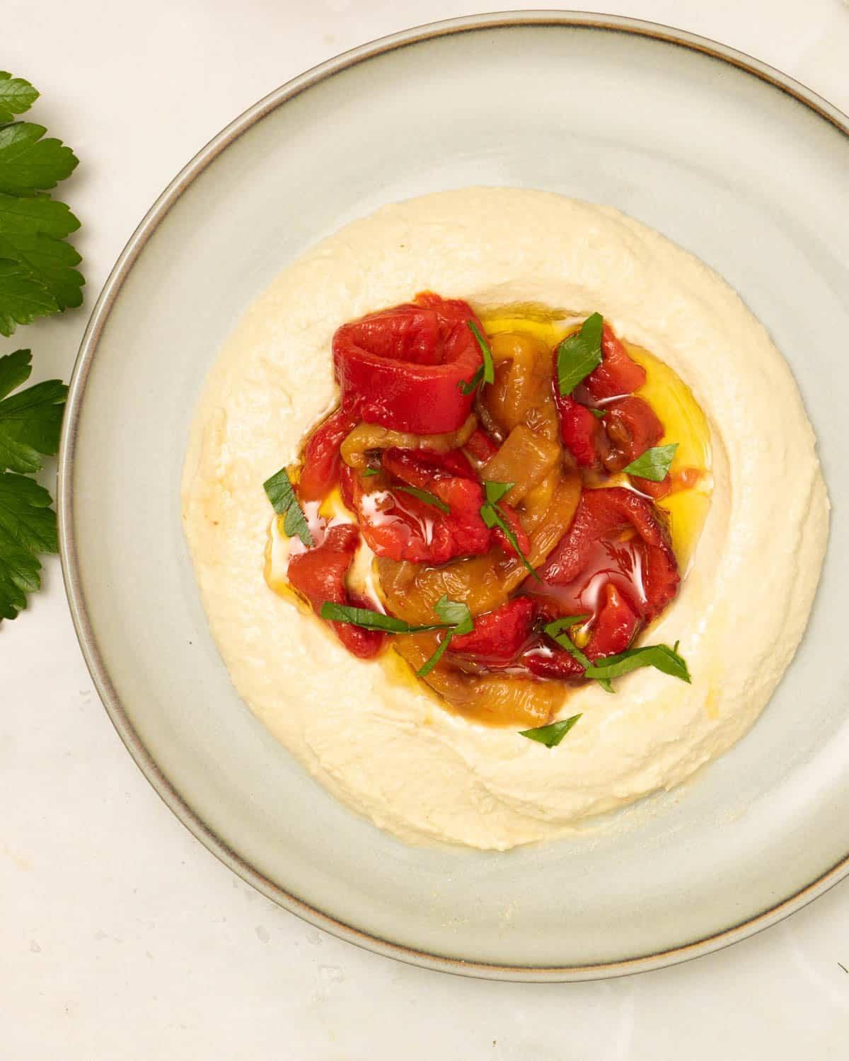 A plate of whipped tofu feta with red peppers on top.