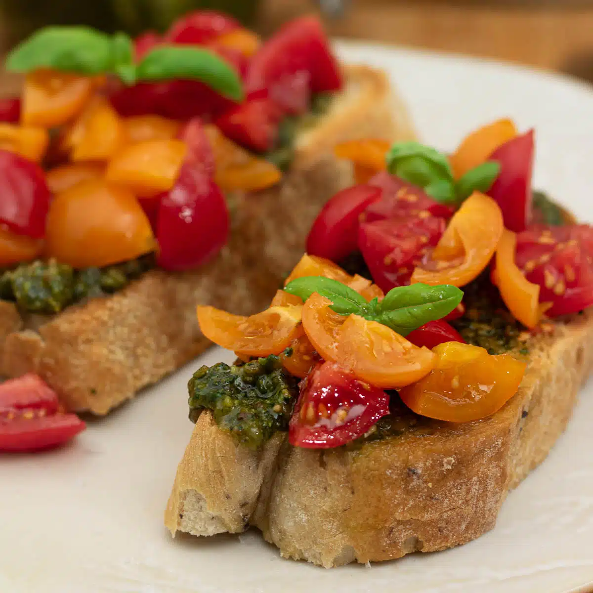 Tomato and Pesto bruschetta on a plate ready to eat.