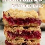 Vegan cranberry shortbread bars, with one being held up to the camera to show the juicy cranberry interior.