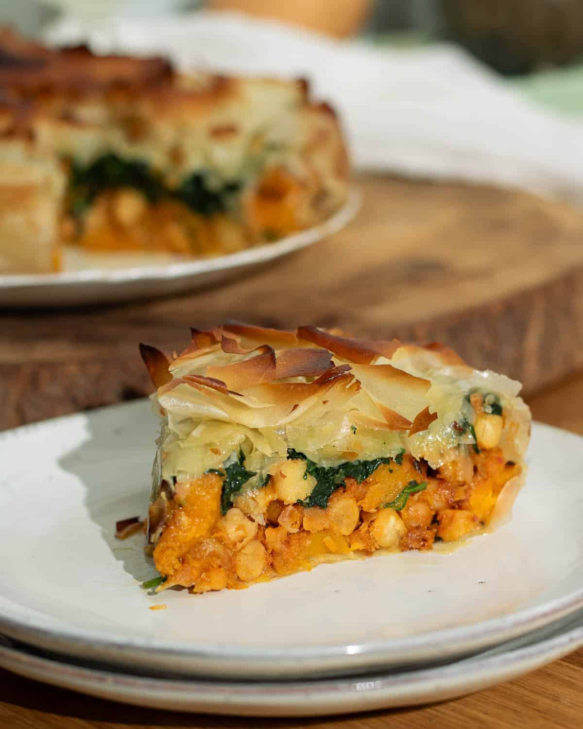 A slice of chickpea and butternut squash filo pie ready to eat on a plate. 