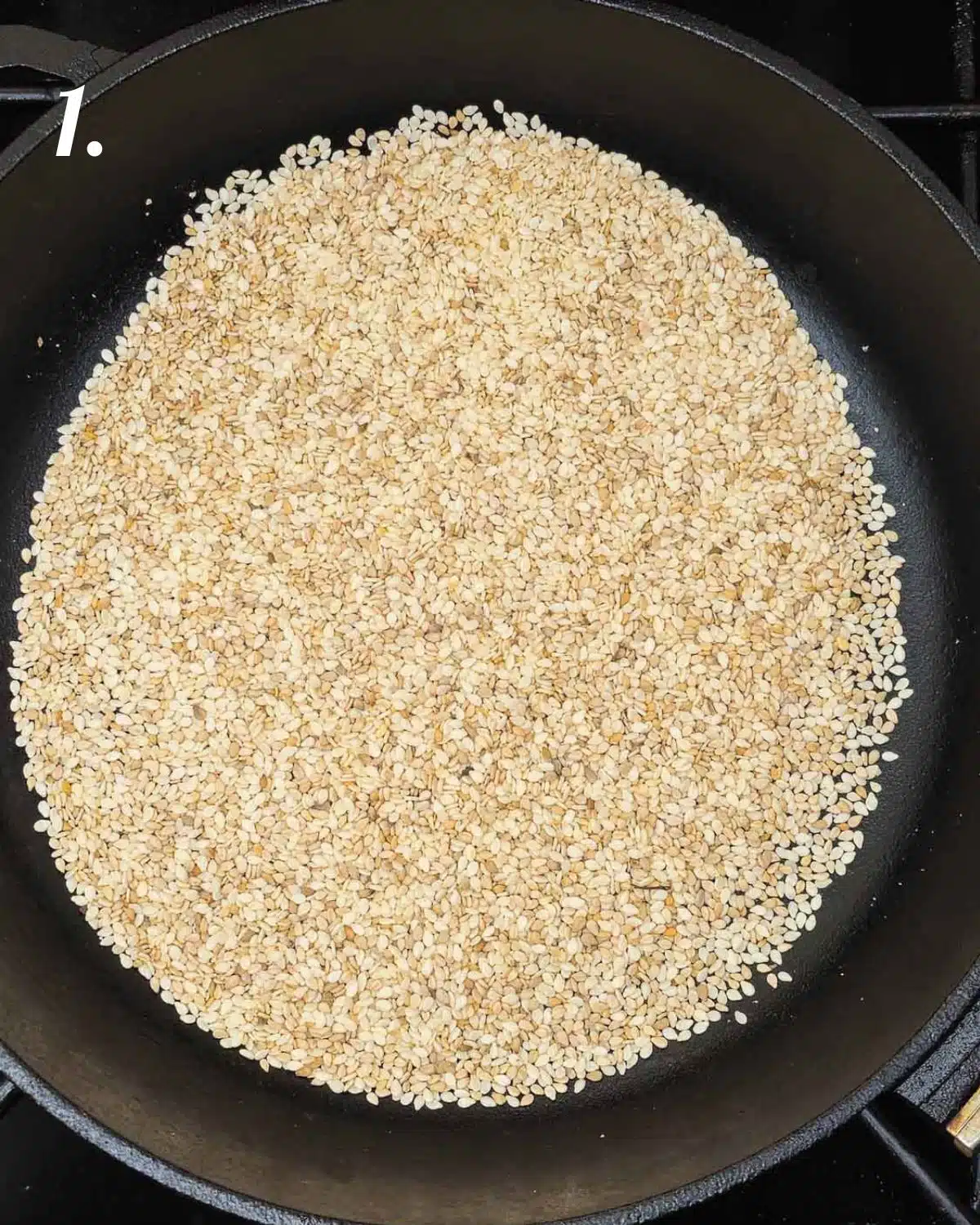Gently roasting the sesame seeds in a pan. 