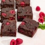 Vegan raspberry brownies cut up ready to eat.