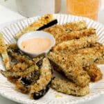 A bowl of crunchy eggplant fries in a bowl with some spicy mayo ready to eat.