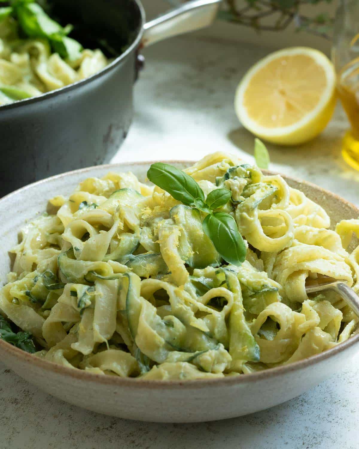 A bowl of zucchini pasta with lemon tofu creamy dressing ready to eat.