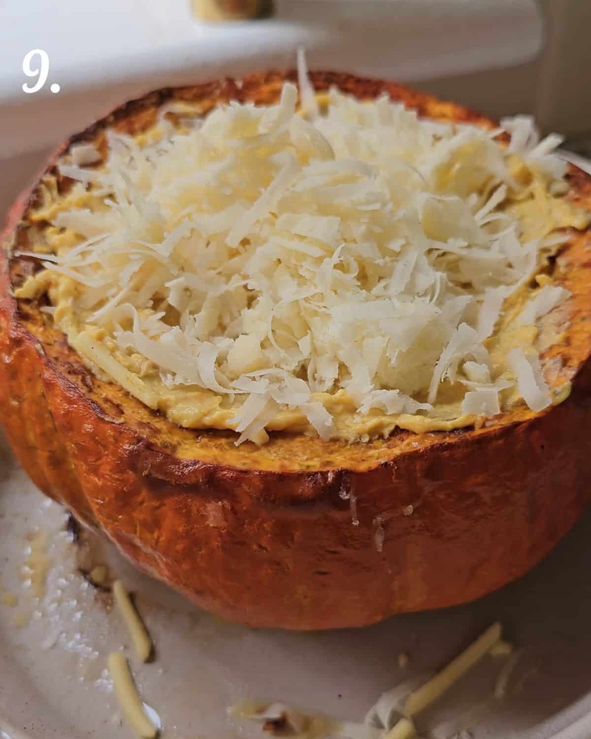 Showing the pumpkin filled and ready to roast with grated cheese on top.