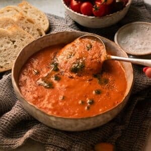 The roasted red pepper and tomato soup ready to eat in a bowl.