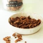 A little bowl of vegan bacon bits with a jar of bacon bits in the background.