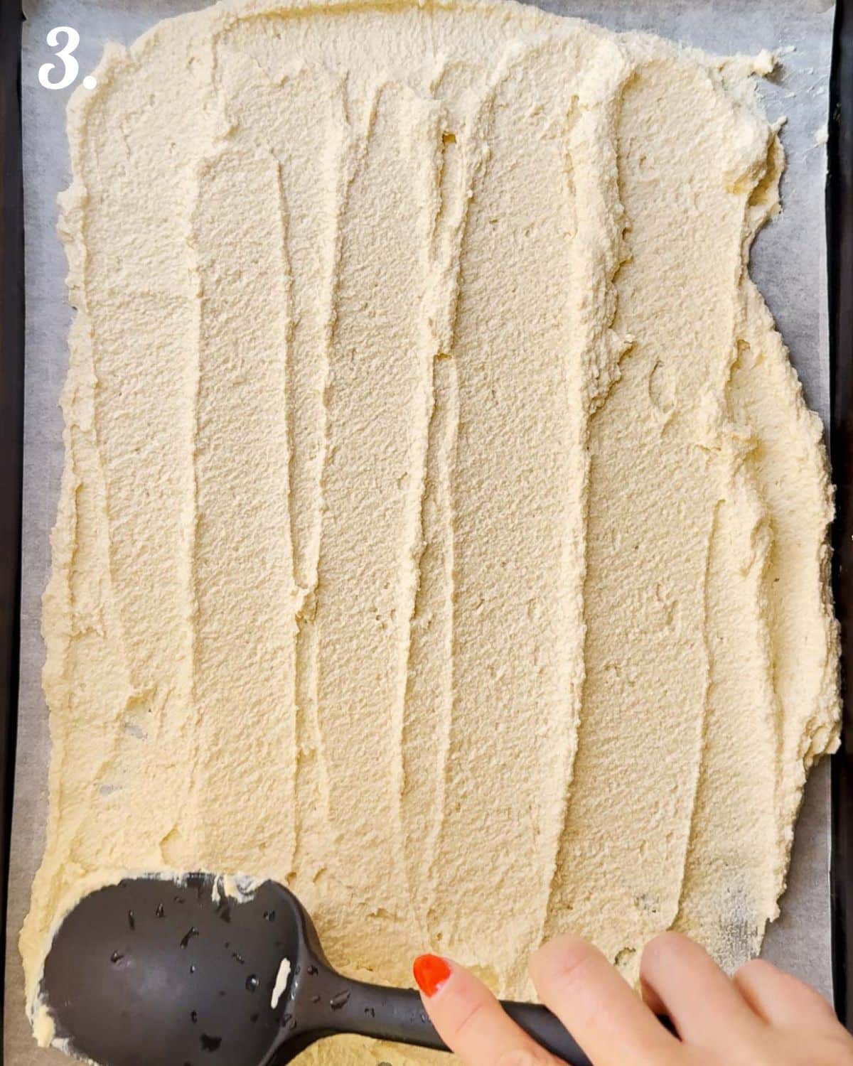 The tofu cracker paste being spread out on a lined baking tray.