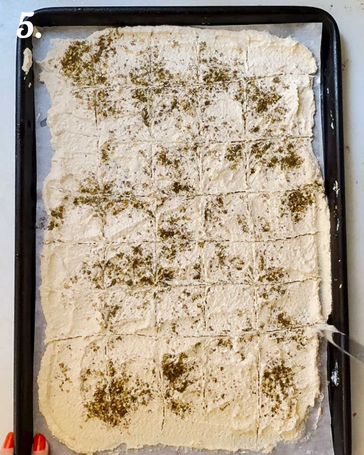 Scoring the crackers into squares before baking.