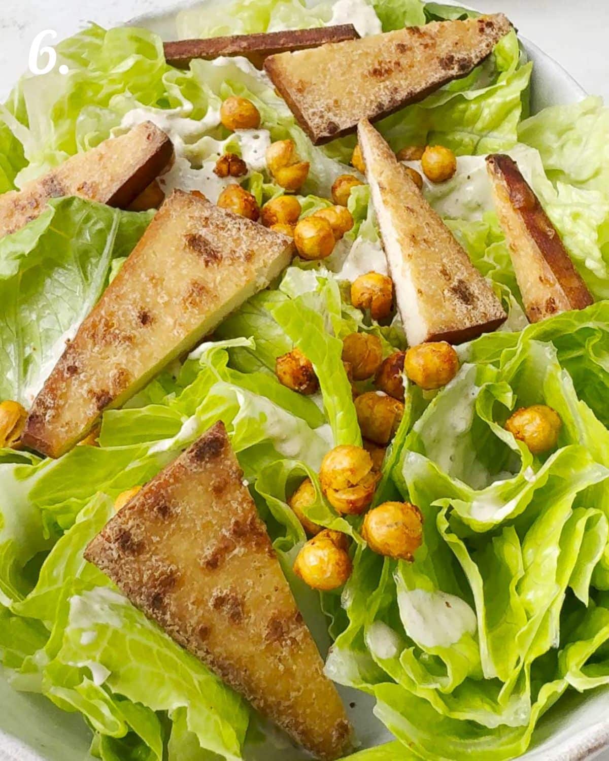 How to layer the caesar salad ingredients before pouring dressing over them. 