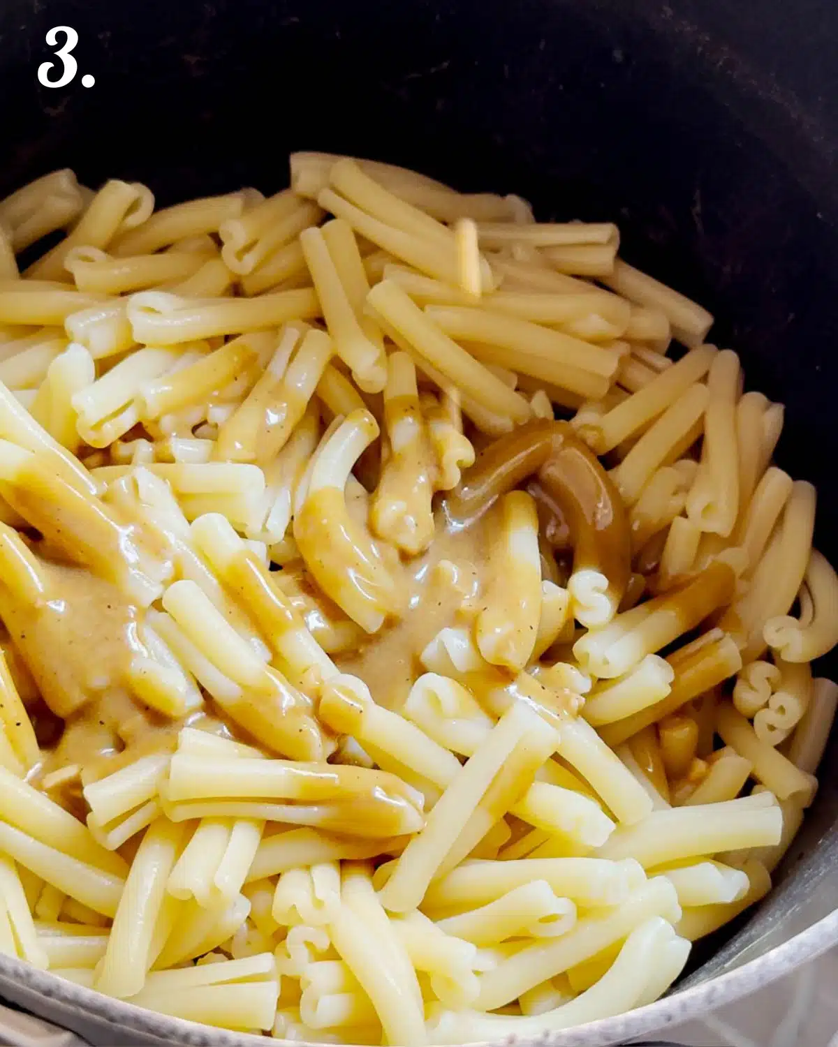 Showing the drained pasta with half the dressing on it ready to use for the salad. 