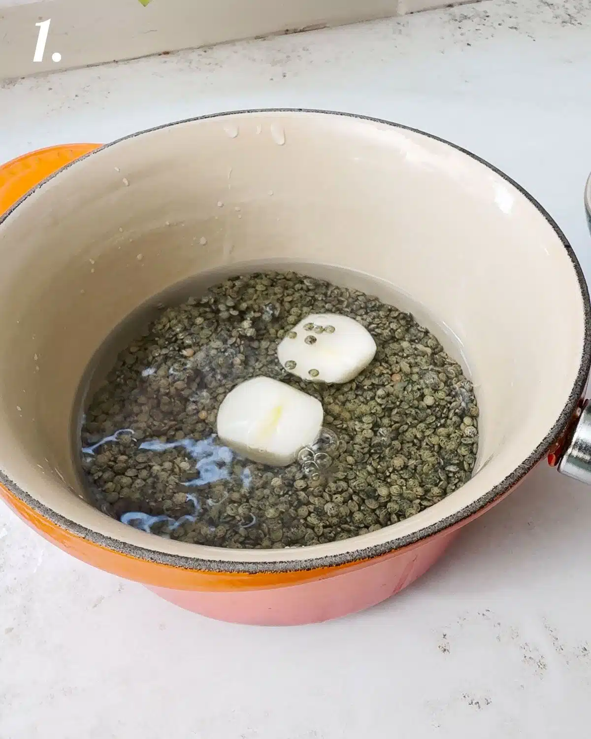 Puy lentils in a pot with water about to simmer on the stove.