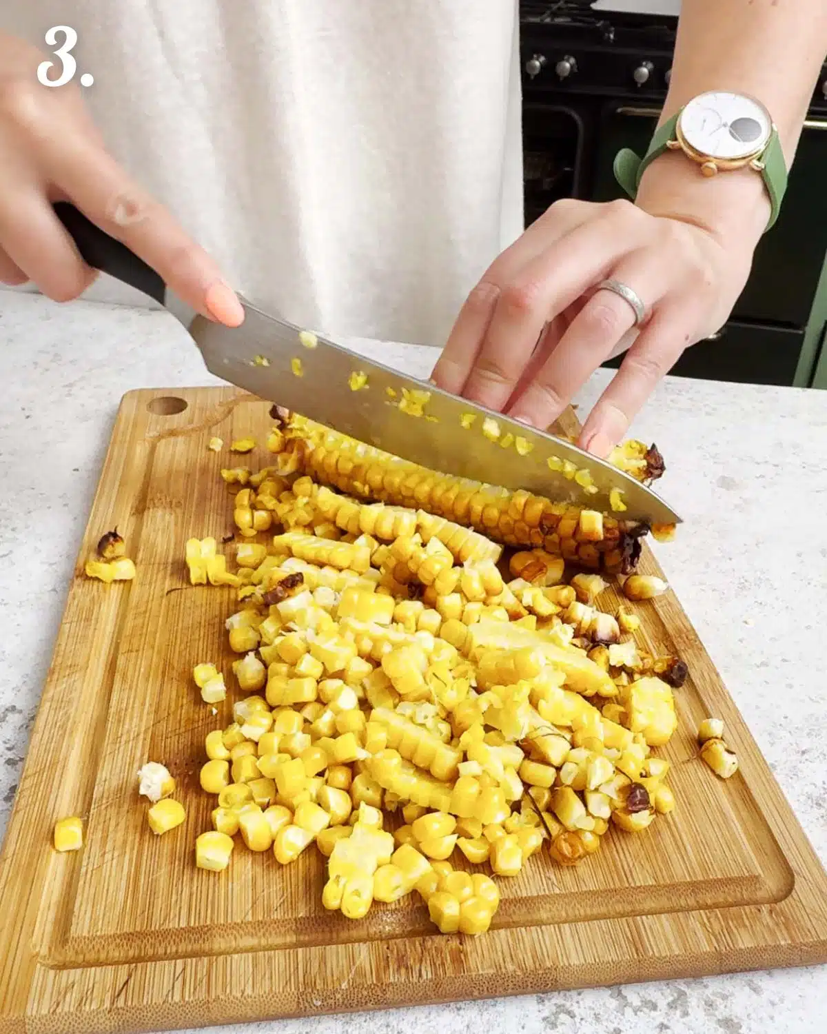 Chopping the kernels off the sweet corn cob.