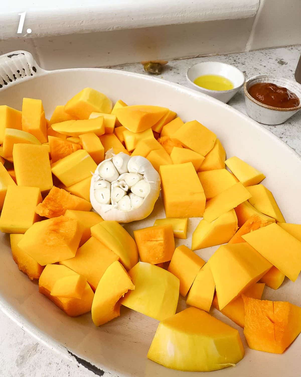 Showing how to roast the squash and garlic as the first step.