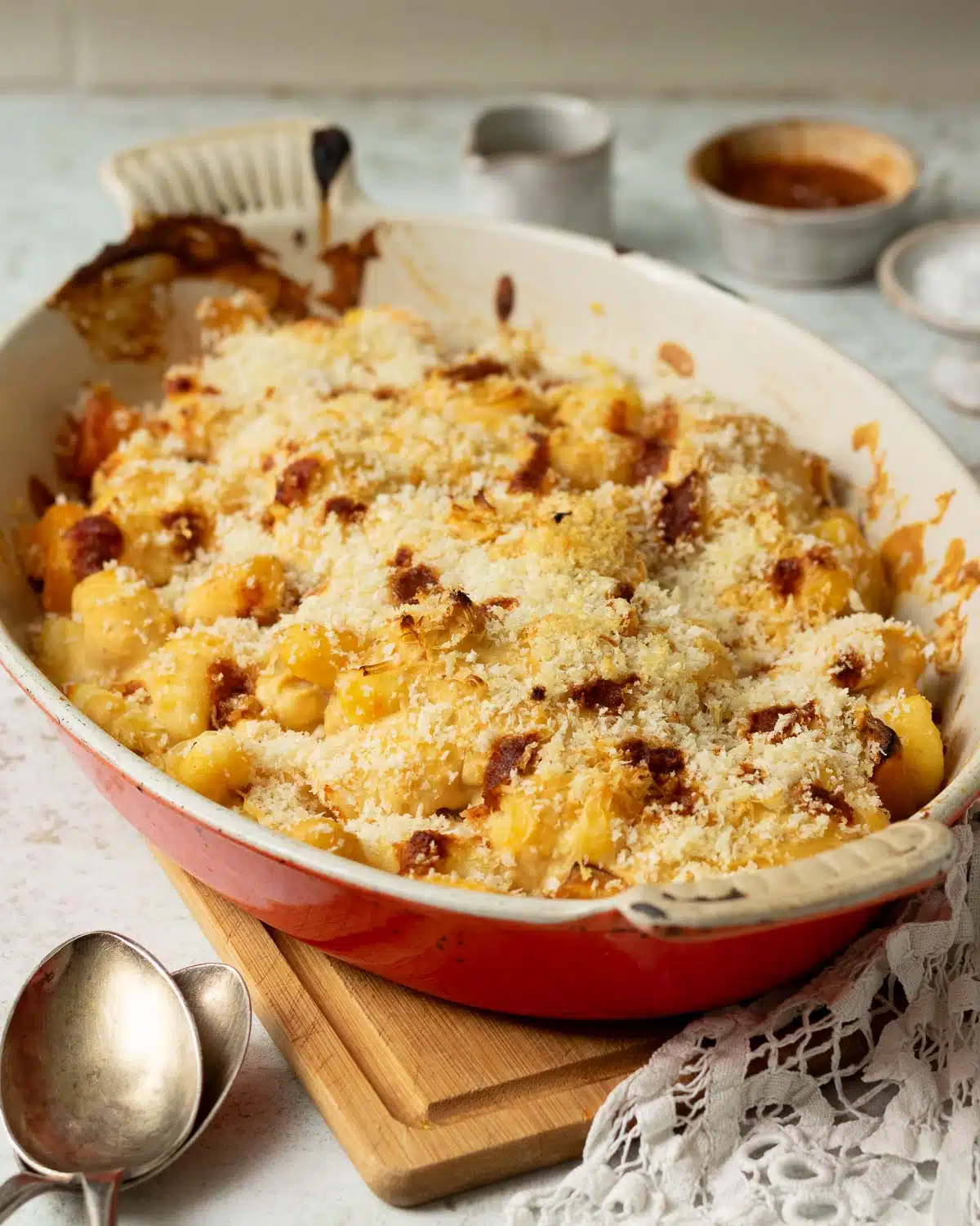 A pan of baked butternut squash and gnocchi with a cheesy harissa sauce and crunchy breadcrumb topping. 