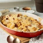 A pan of baked butternut squash and gnocchi with a cheesy harissa sauce and crunchy breadcrumb topping.