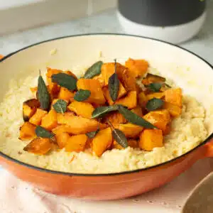 A bowl of butternut squash risotto with crispy sage leaves on top ready to serve.
