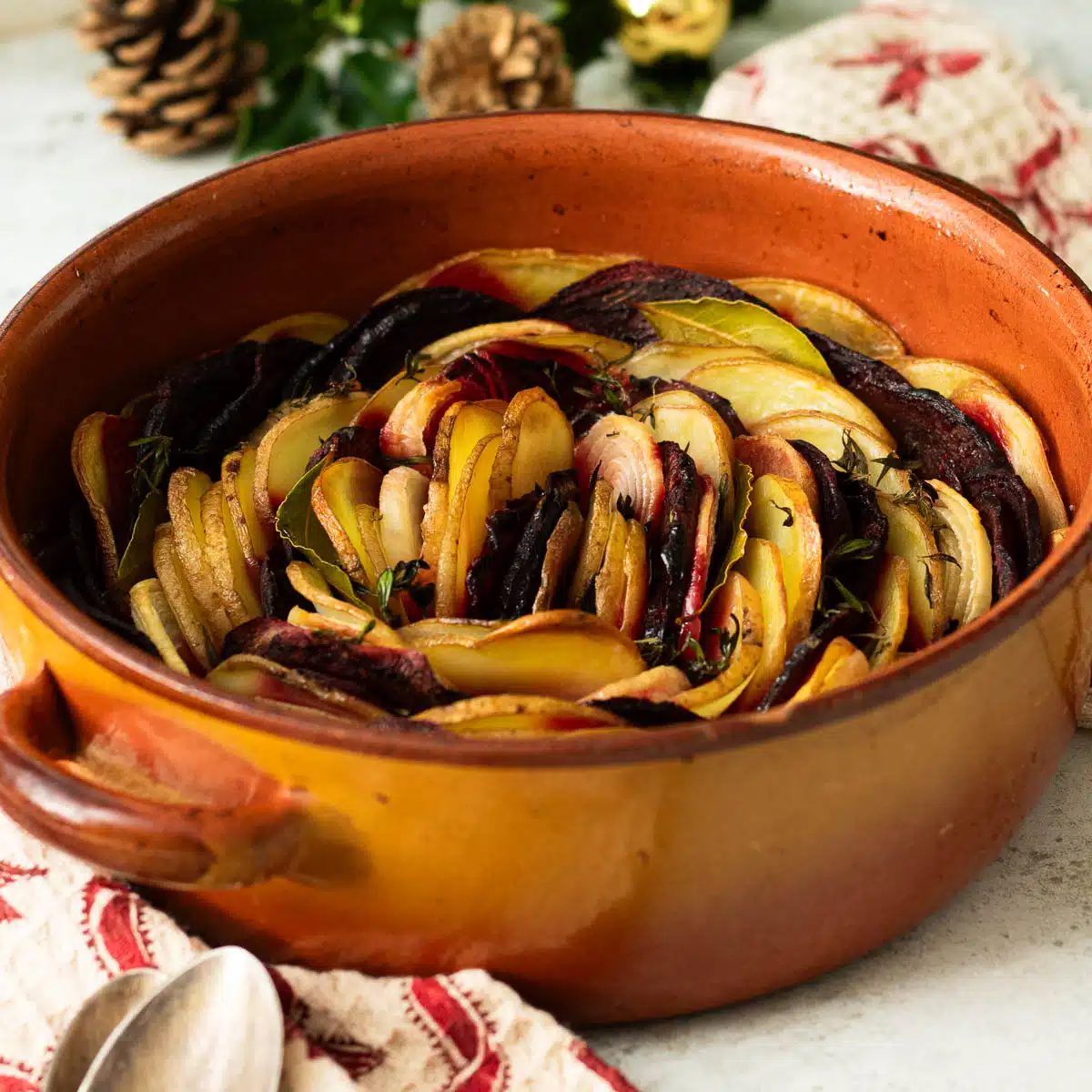 A dish of layered potatoes and beetroot boulangere style ready to serve.