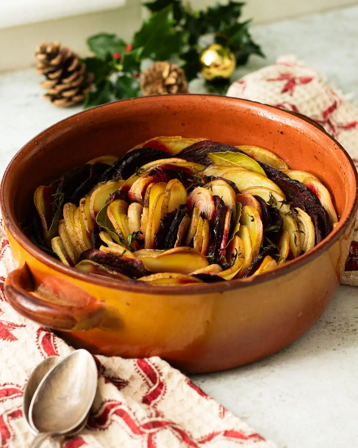A dish of layered potatoes and beetroot boulangere style ready to serve.