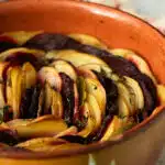 A dish of layered potatoes and beetroot boulangere style ready to serve.